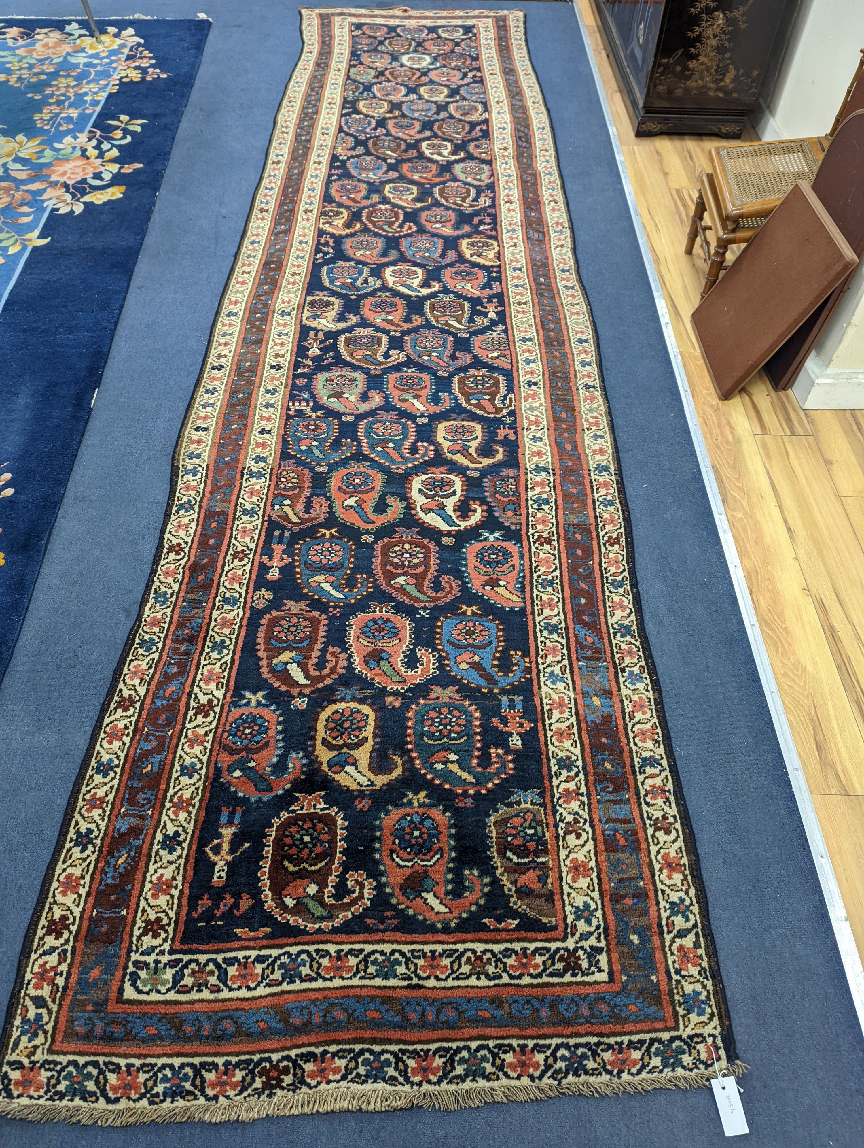 A Caucasian Karabagh blue ground runner, woven with rows of stylised boteh, figures and birds, 477 x 117cm